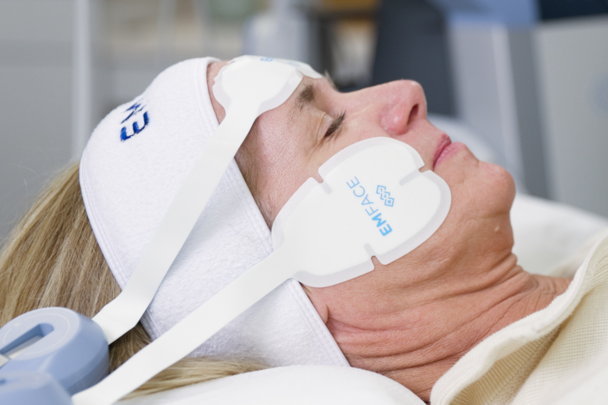 A woman is lying down with applicators on her face for Emface in Mt. Pleasant, SC.