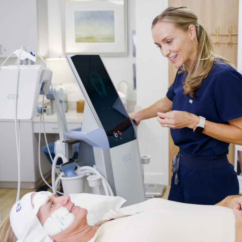 A woman is lying down and receiving her Emface treatment for body contouring in Mt. Pleasant, SC.