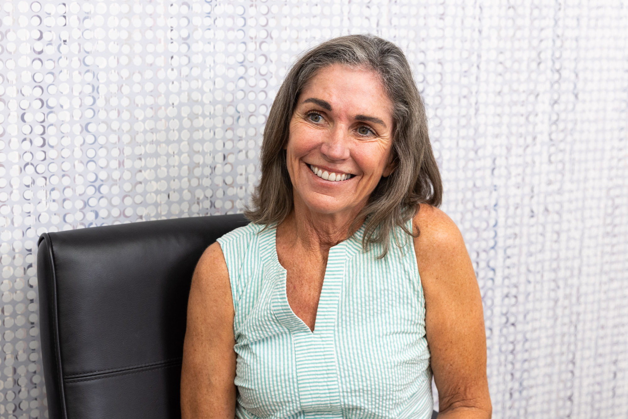 A woman is speaking with an InterveneMD provider to learn more about the Elite Facial.