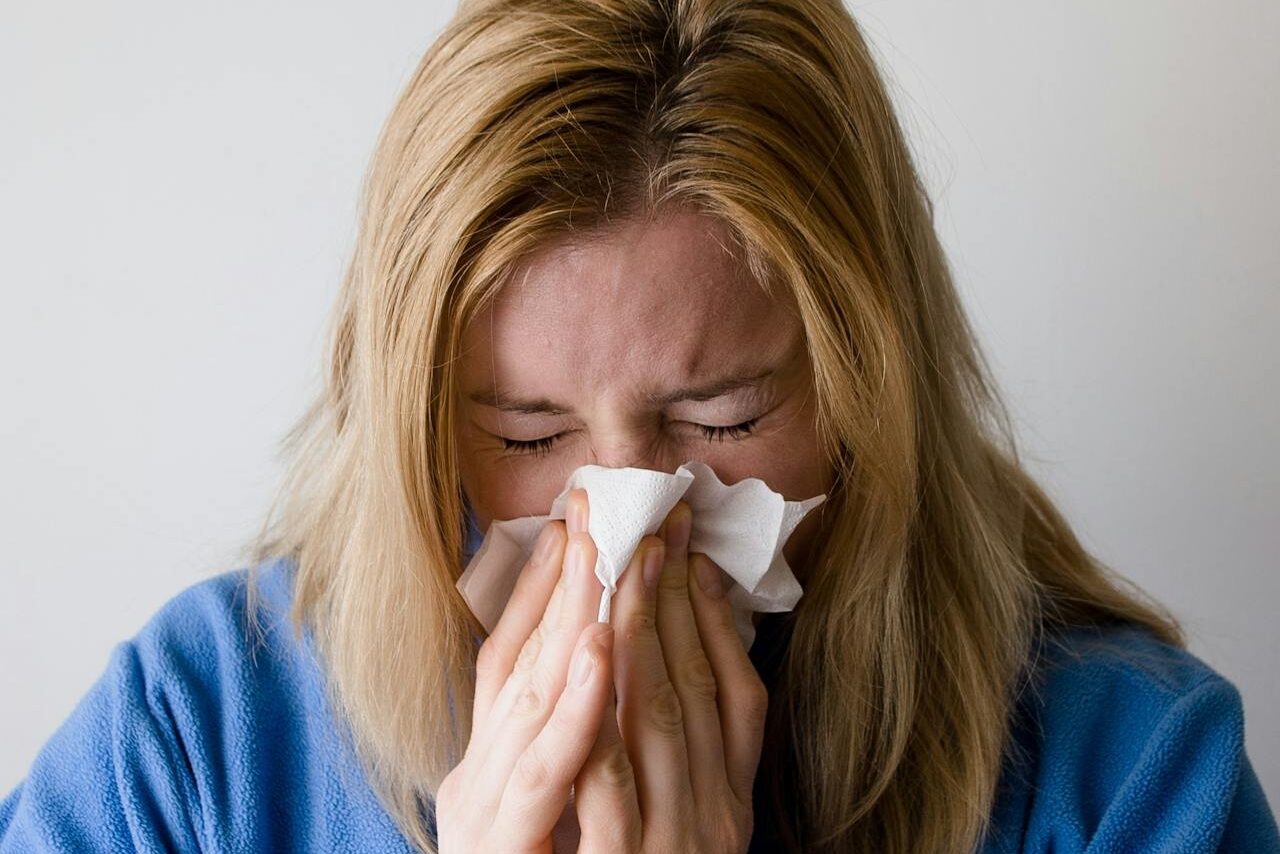 A woman experiences reduced immunity, a condition commonly connected to gut dysbiosis treated by our gut health doctor in Charleston.