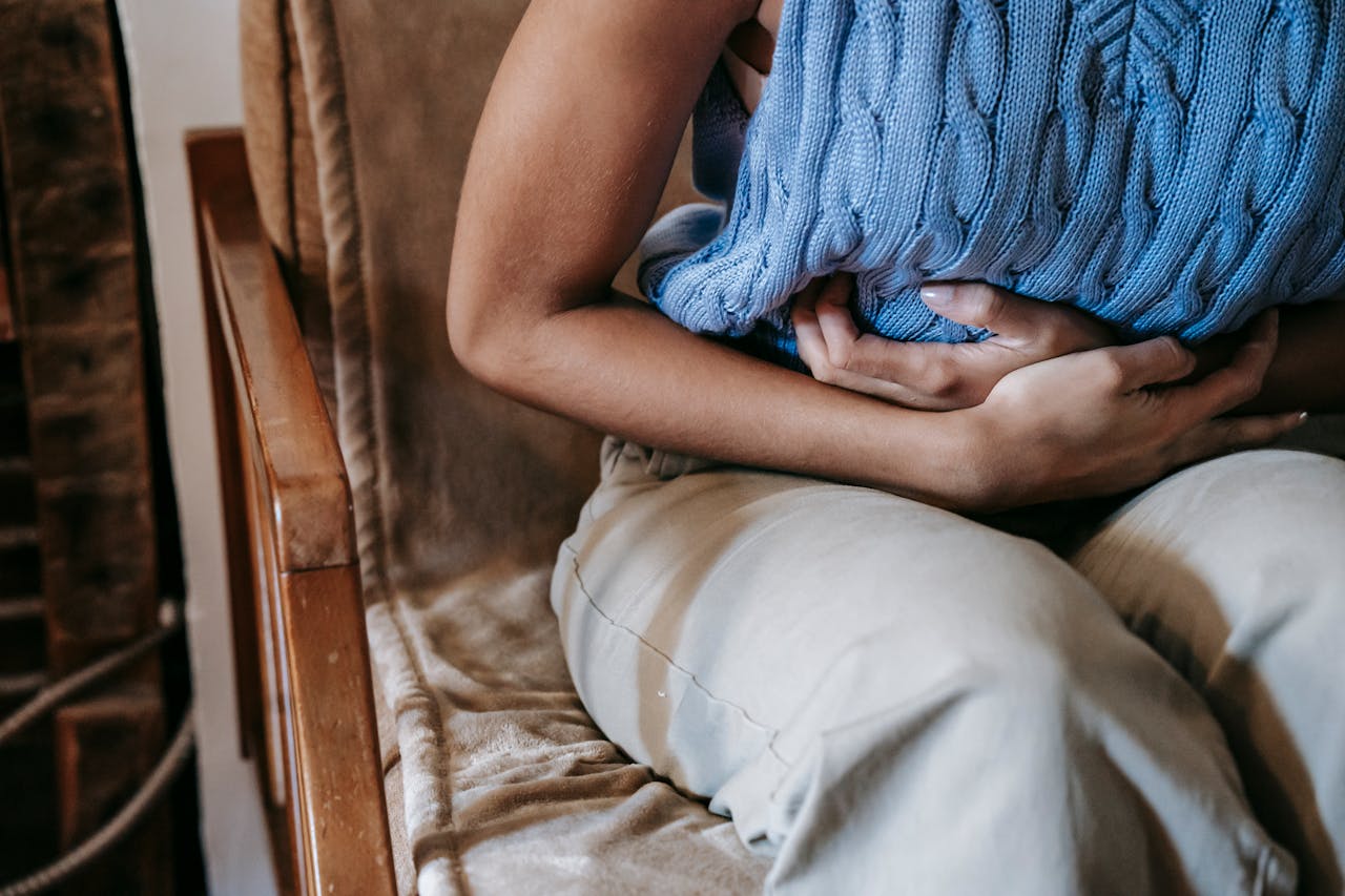 A woman struggles with IBS prior to seeking a gut health doctor in Charleston.